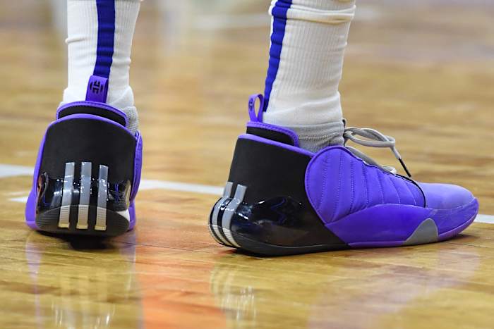 View of purple and black adidas shoes.